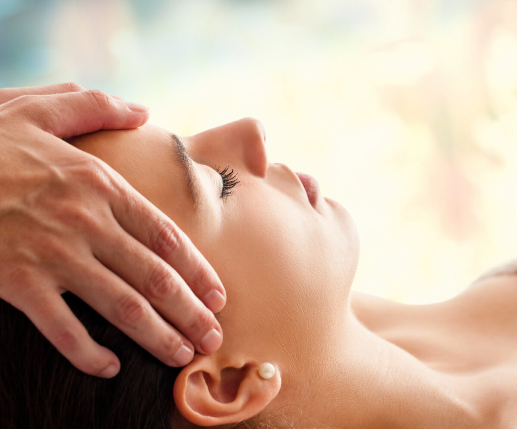 Massage therapist working on woman's head