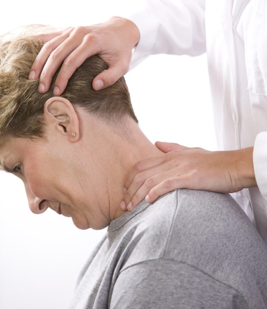 Chiropractor checking woman's neck movement